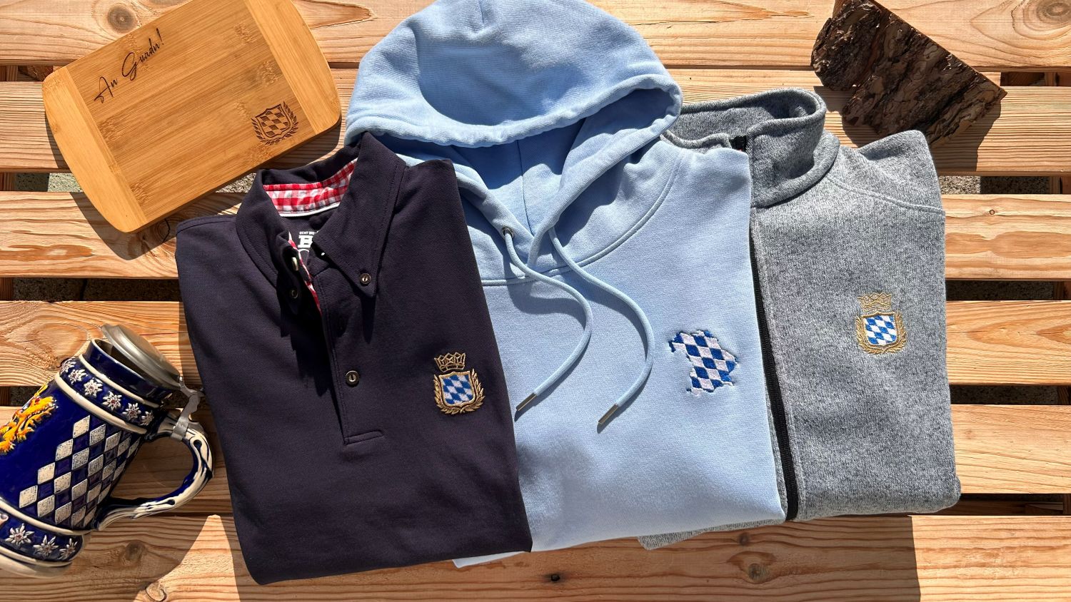 Bayerische Poloshirts Hoodies und T-Shirts mit dem Bayern Wappen bestickt von BavaRosi Fashion Bayerische Jacken und Strickjacken mit Wappen Stickmotiv weiss blau der Serie Royal Bavarian und Homezone Bayern